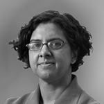 Et portrett av en kvinne med kort krøllet hår og briller