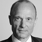 Black and white portrett av en eldre mann med kort hår, målt til nakken, iført dress og hvit skjorte.