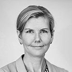 Sort-hvitt bilde av en kvinne med kort hår og dress, ser mot kameraet.