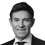 Et svart-hvitt portrett av en mann med mørk, kort hår, iført mørk dress og slips.