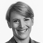 Et svart-hvitt portrett av en smilende kvinne med kort hår.