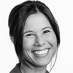 Et svart-hvitt bilde av en smilende kvinne med kort hår