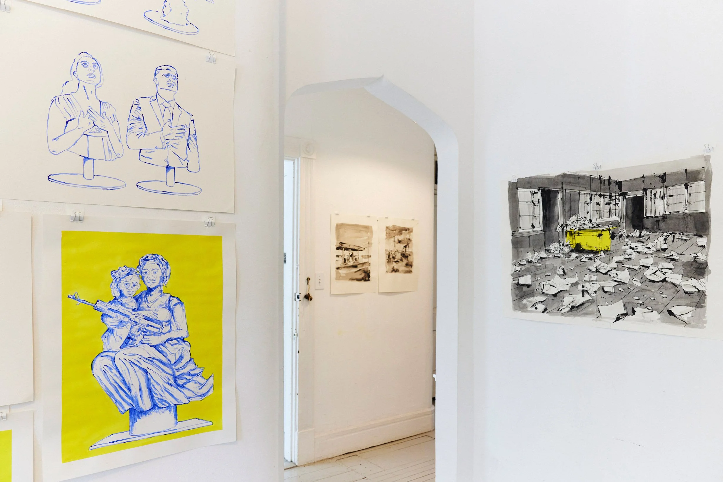 Art gallery wall with line drawings of people, a bright yellow poster with a sketch of a woman and child holding a gun, and a monochrome painting of a cluttered room with a yellow rectangle in the center.