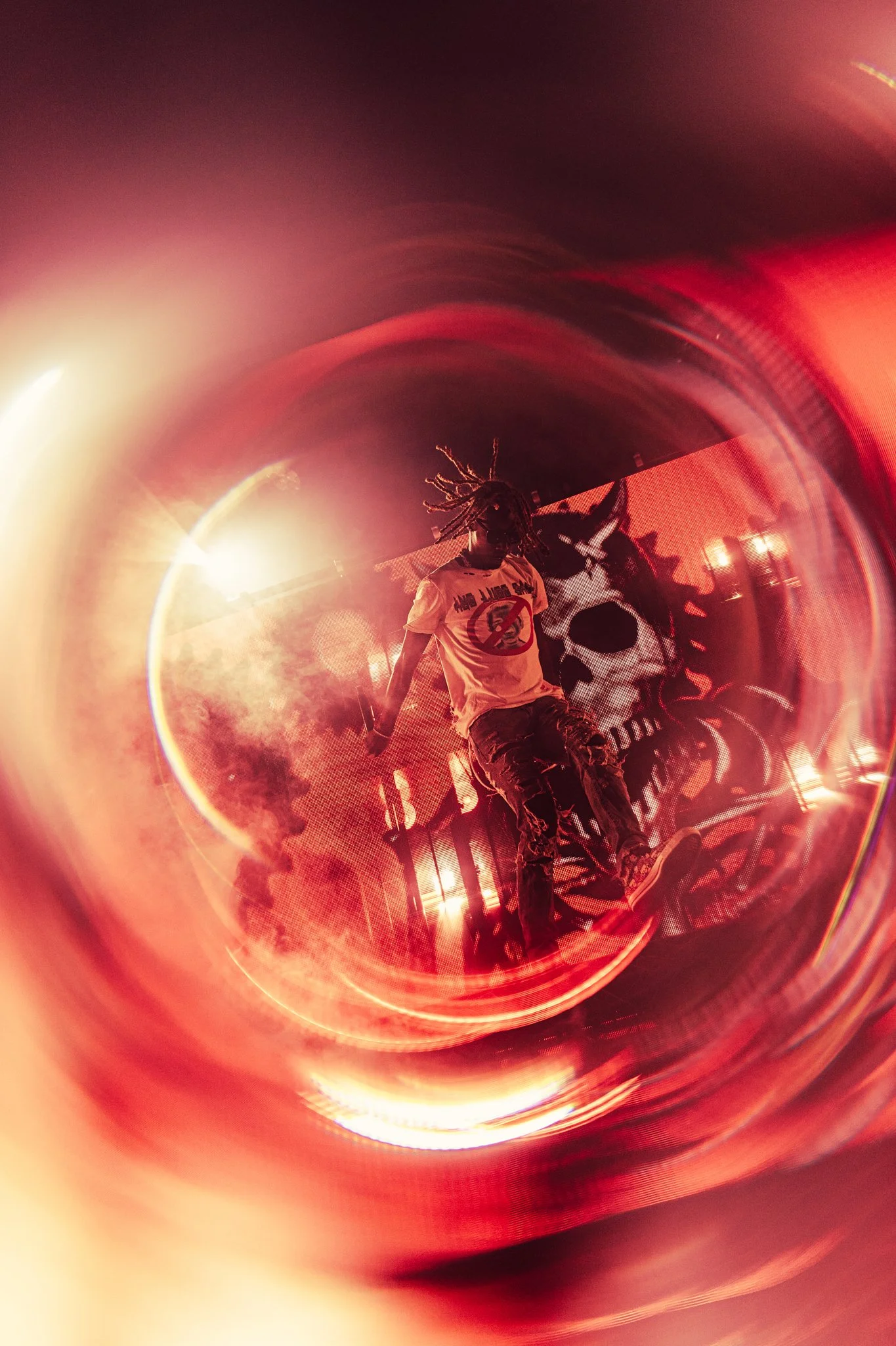 Rapper Osamason in Amsterdam Melkweg, taken through a reflective or distorted surface with red lighting effects.