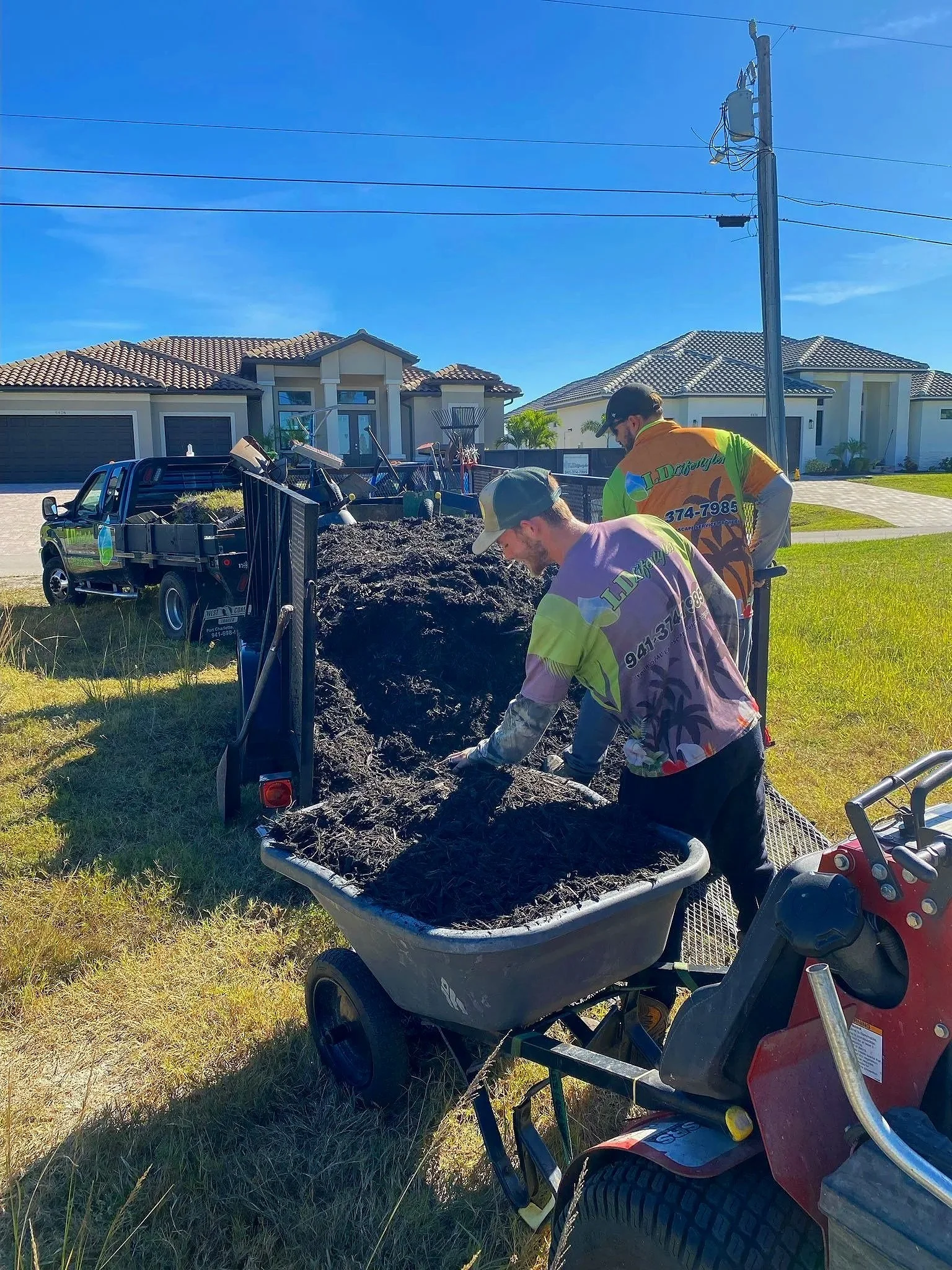 LD Lifestyles team loading up wheelbarrows to provide fresh mulch for HOA community in Punta Gorda, FL.