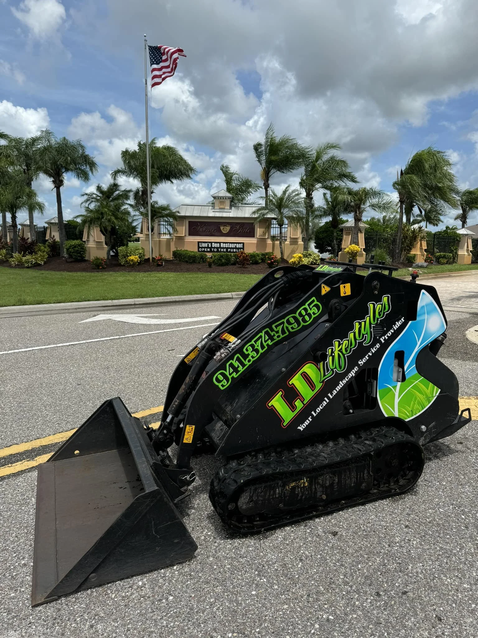 Kings Gate HOA Community freshly mulched in the background of LD Lifestyles mini skid steer in Port Charlotte Florida.