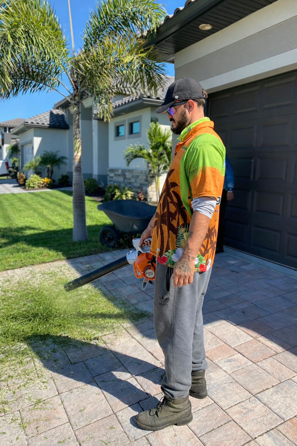 LD Lifestyles worker blowing off grass after mowing a lawn at Punta Gorda home.