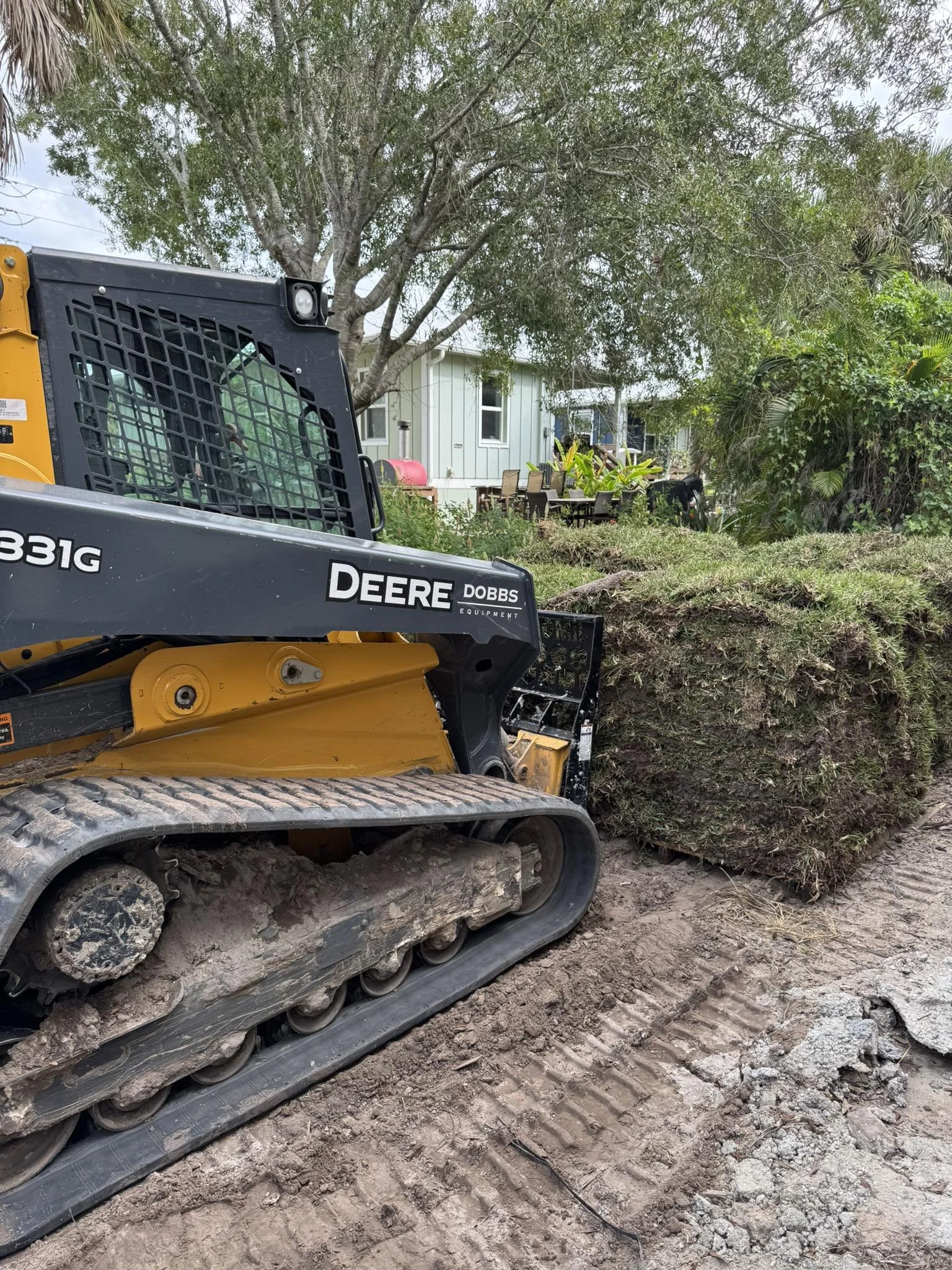 LD Lifestyles crew member inside a tractor installing St. Augustine sod at Port Charlotte home.