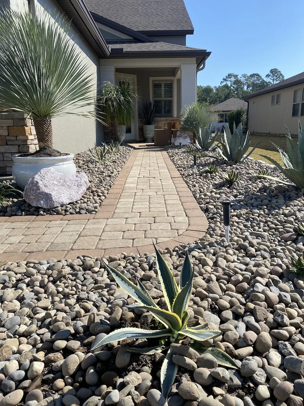 Paver walkway, rocks, and low maintenance plants installed by LD Lifestyles for a Punta Gorda homeowner.