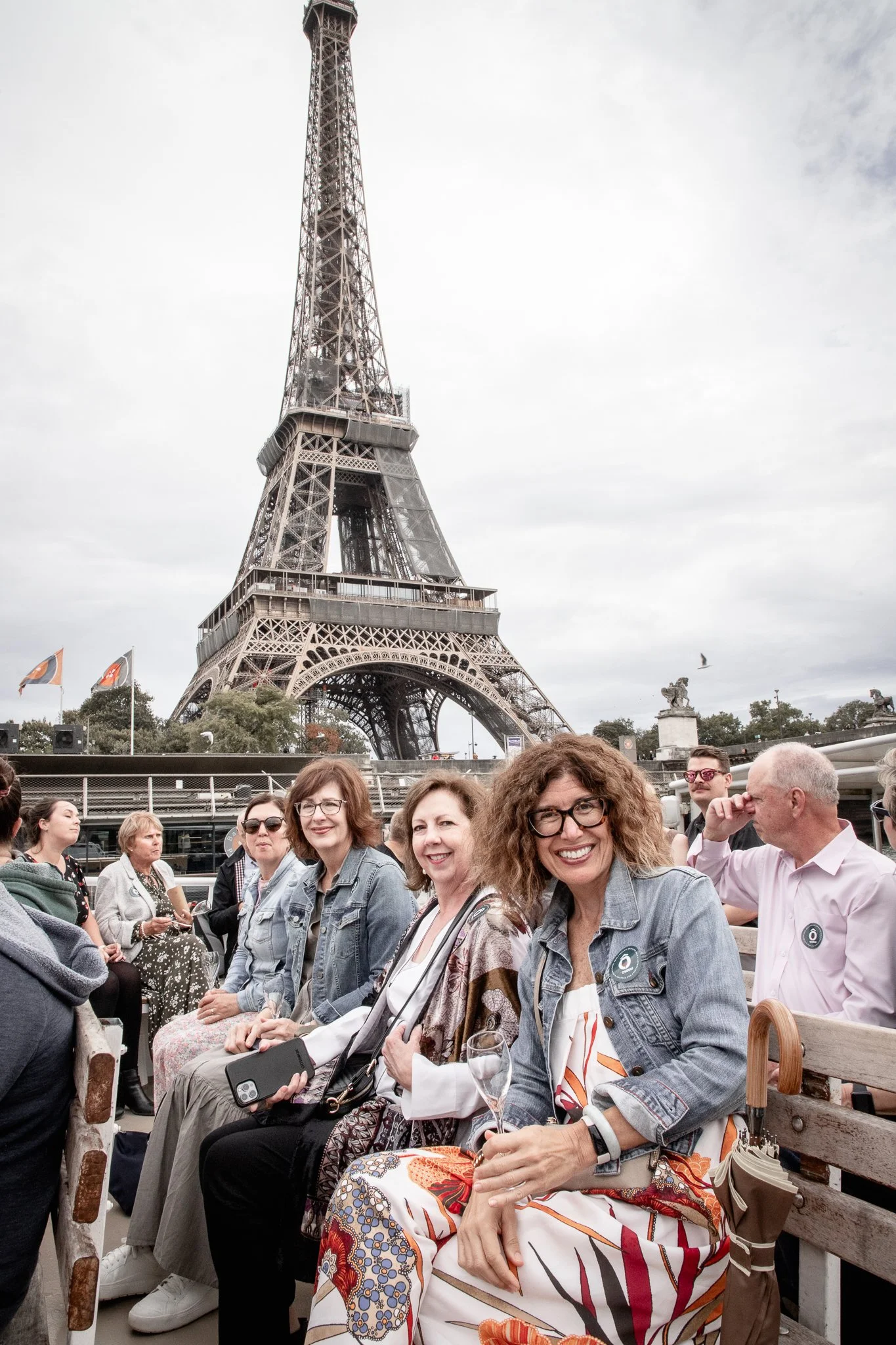 A group of women sitting on benches near the Eiffel Tower in Paris, France.