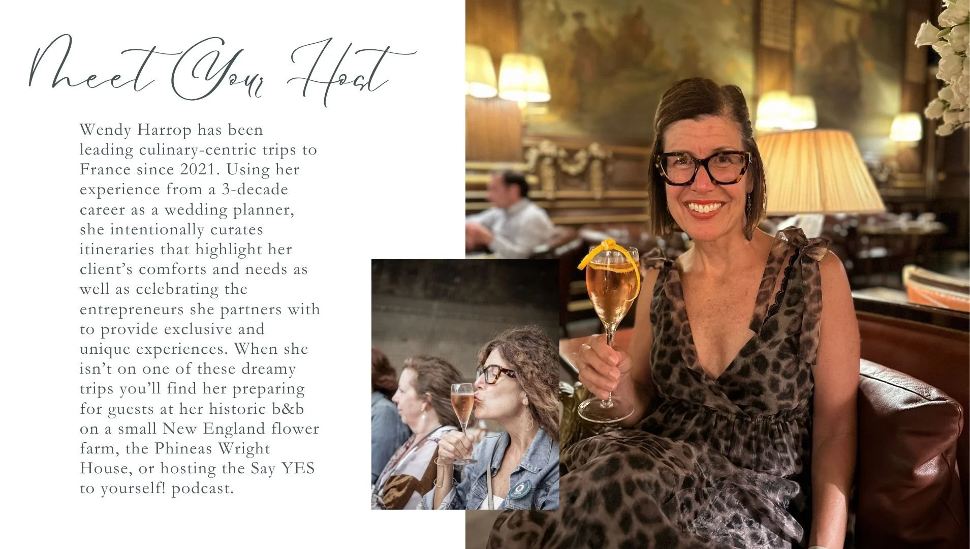 A woman with glasses, smiling, wearing a leopard print dress, sitting in a restaurant or bar holding a drink with a lemon twist. Behind her are warm lighting, lamps, and a decorative wall. There are also other people in the background.