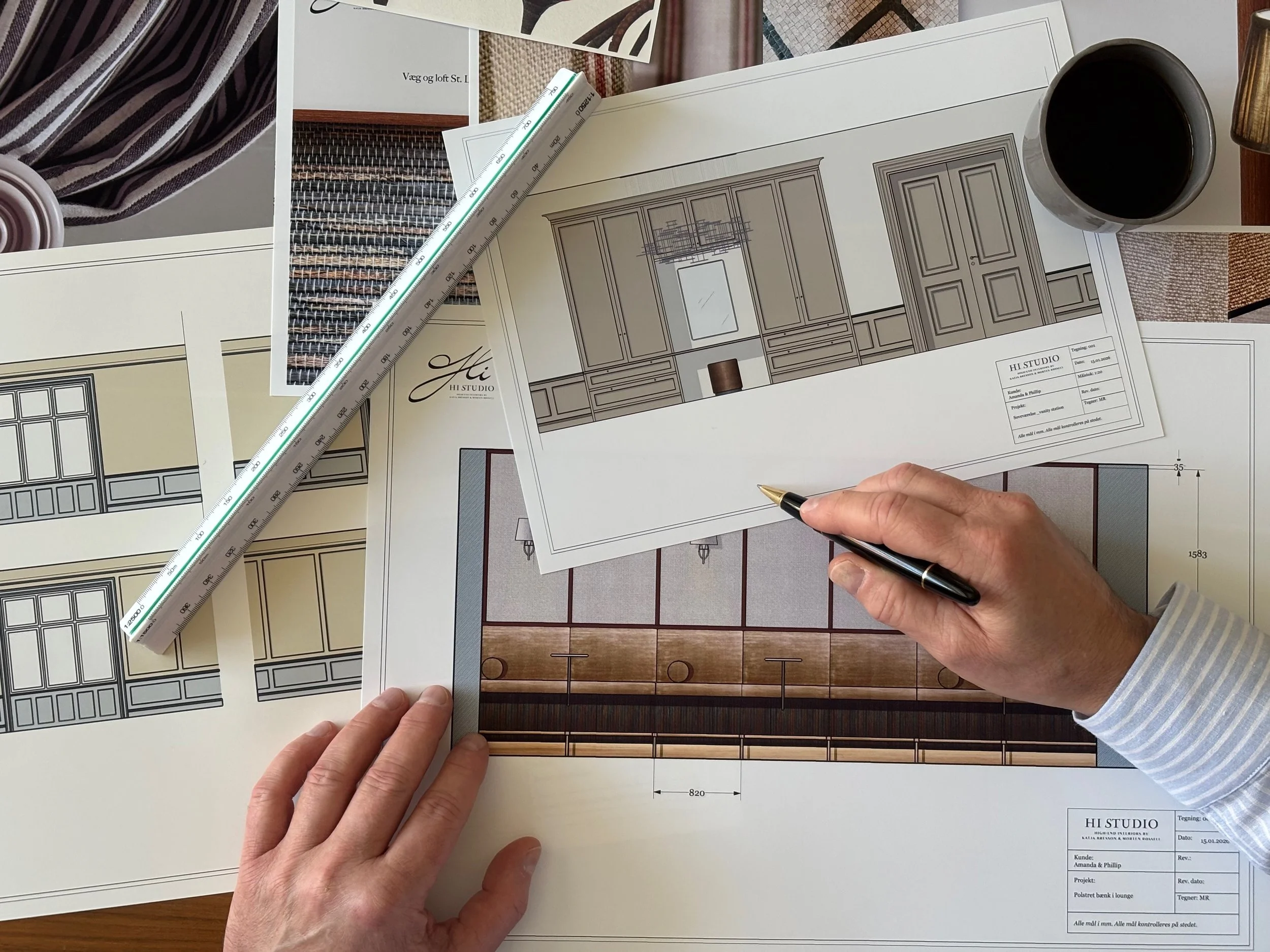 Arkitekttegninger og prøver af indretning, værktøj og en kop kaffe på bordet.