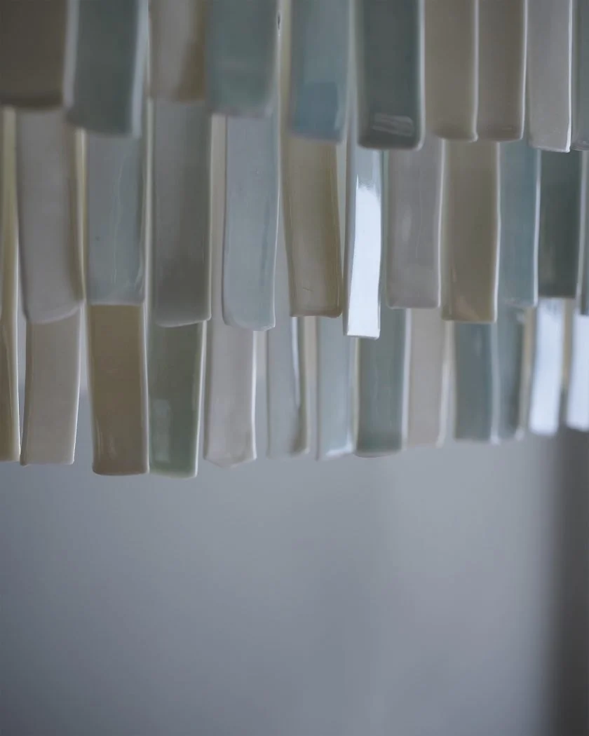 Nærbillede af en række af farvede plastikrør eller -stave hængende i en lodret linje.