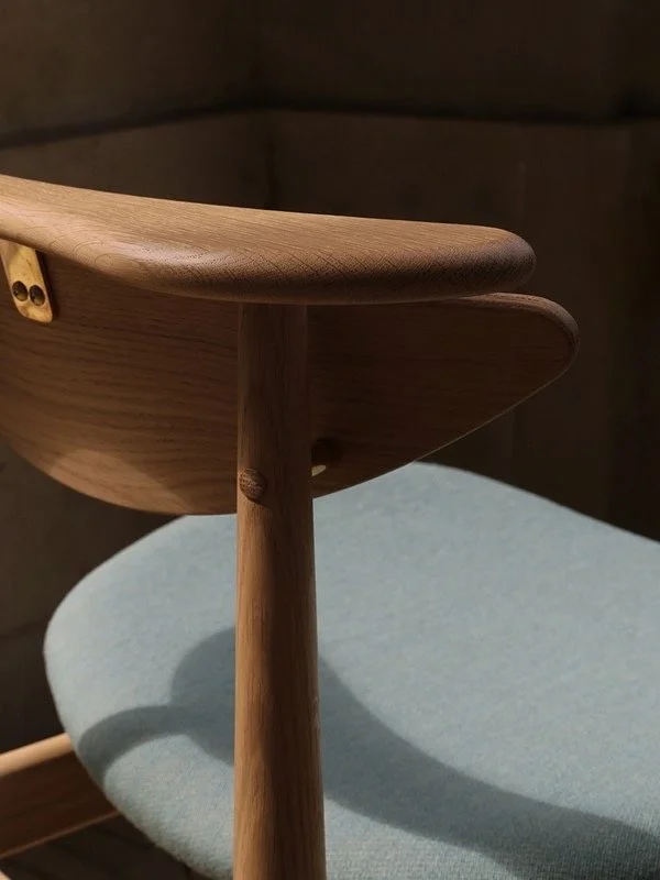 Nærbillede af en træstol med en træskål eller båd, der er på plads.