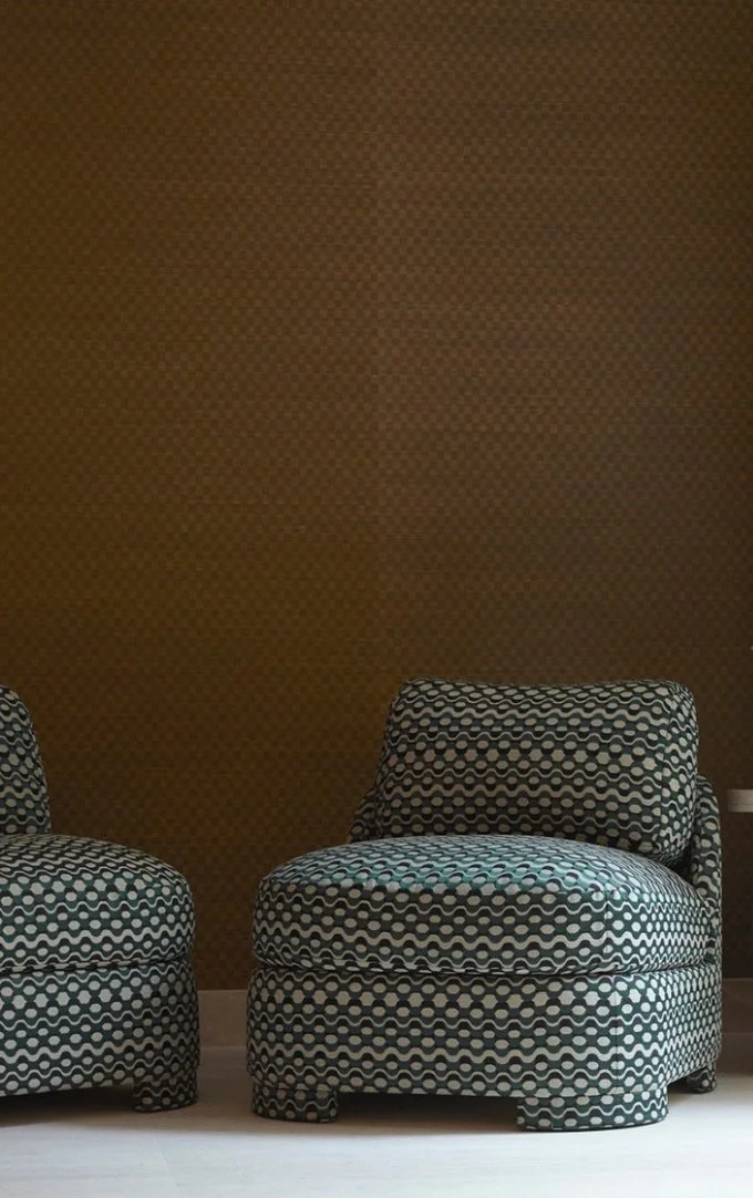 To polstrede lænestole med sort, hvid og grå geometrisk mønster foran en brun væg. Moebler på et lyst trægulv.