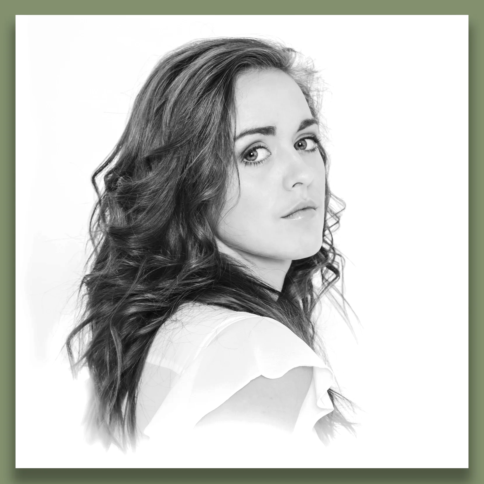 Black and white portrait of a woman with wavy hair, looking over her shoulder at the camera.