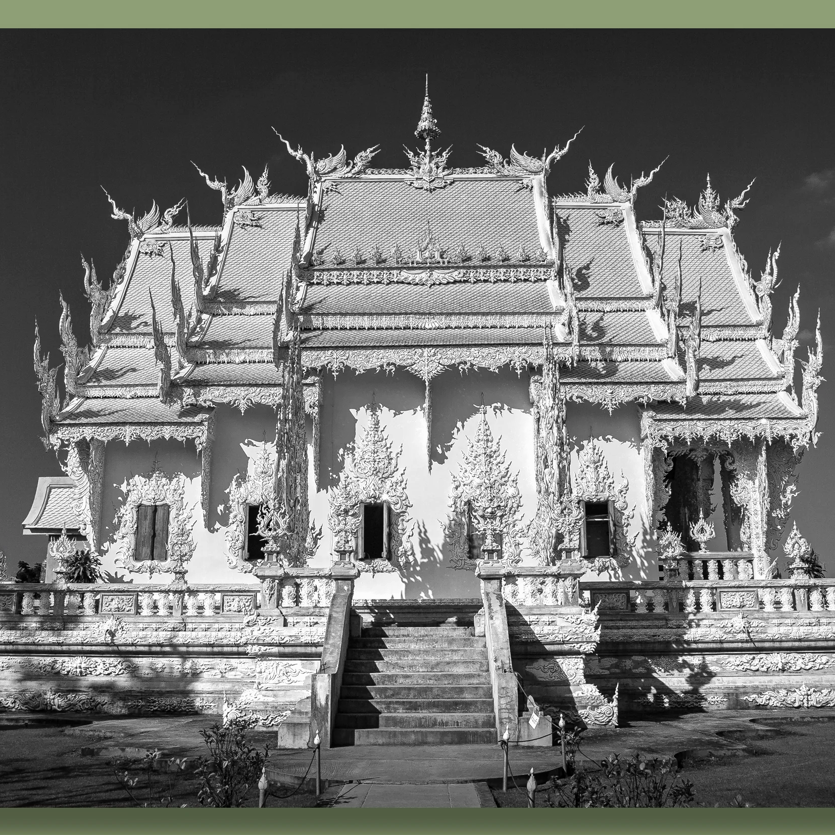 A temple in Chiang Mai, with intricate architectural details and tiered rooflines, situated against a clear sky.