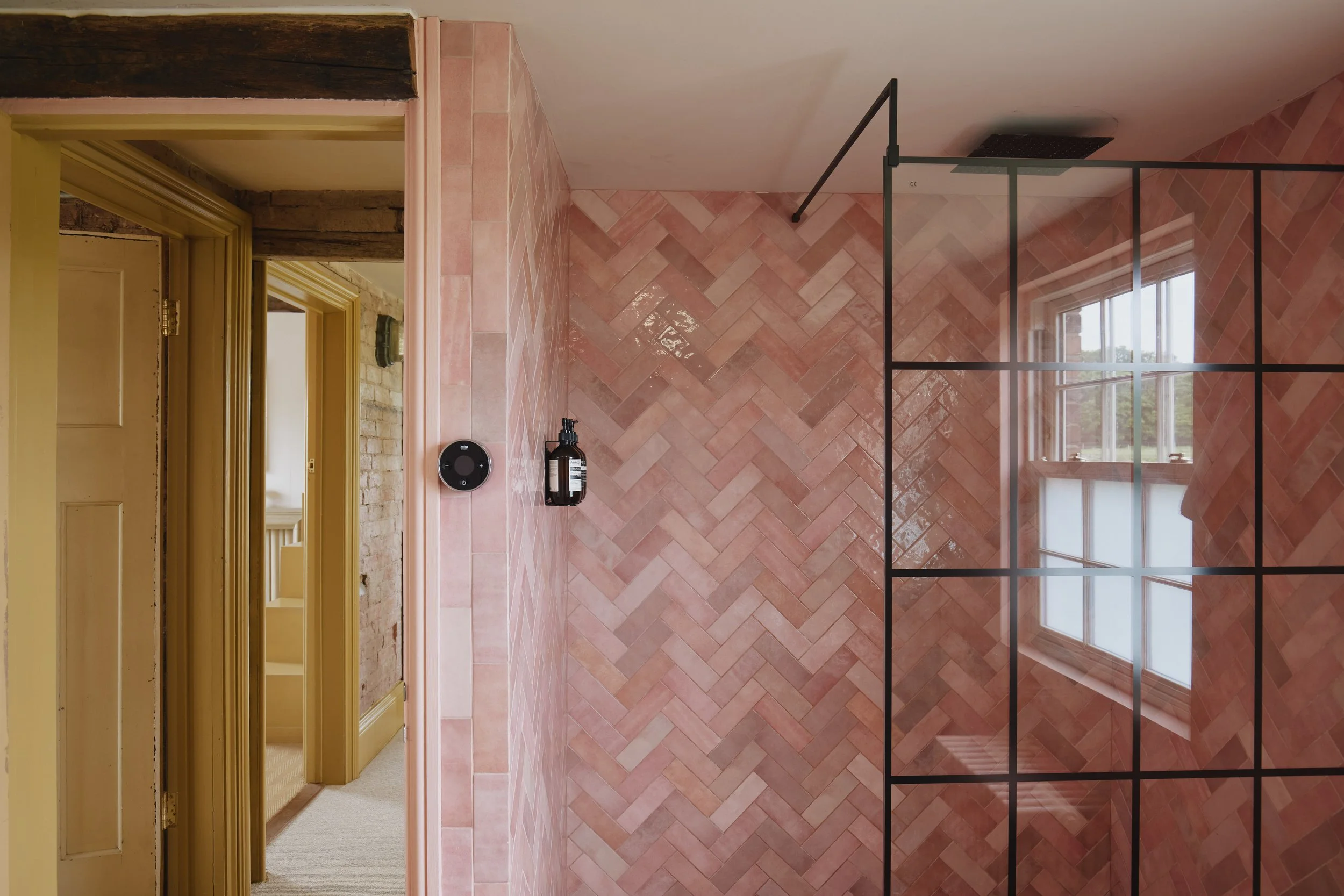 The shared bathroom features a pink tiled walk-in shower