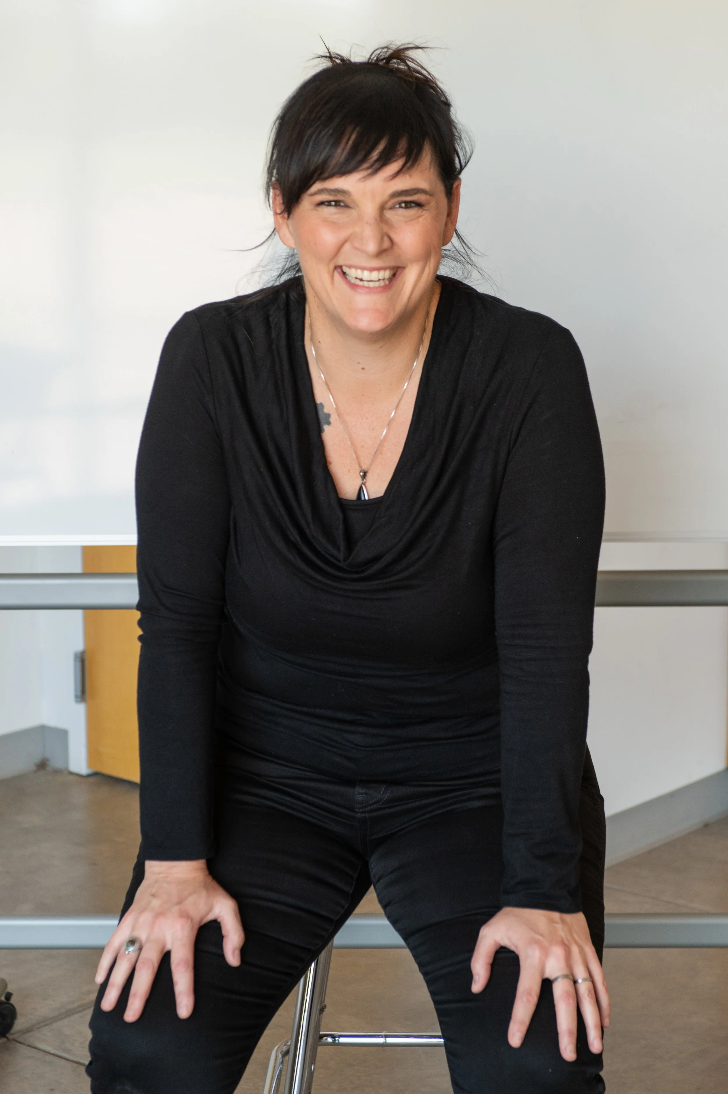 Leadership practitioner smiling in a relaxed seated portrait