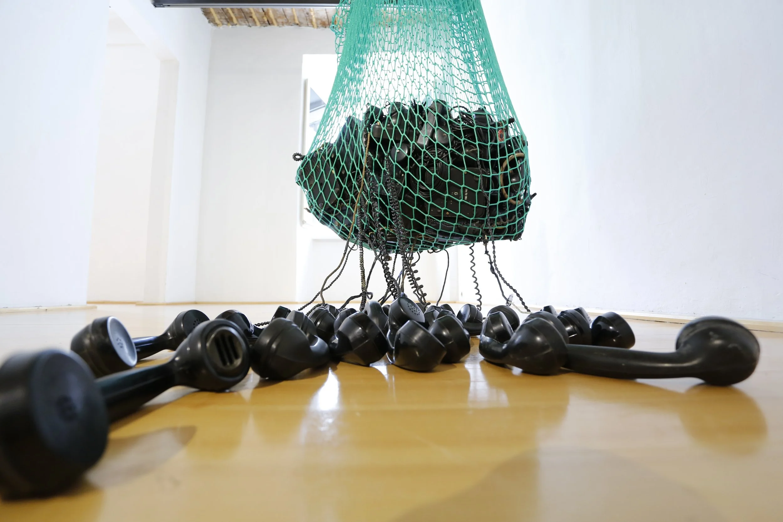 Nahaufnahme, Kunstinstallation, Netz das schwarze Telefone hält,  Kulturzentrum bei den Minoriten, Graz, Ausstellung des aktuellen Künstlers Eduard Winklhofer aus Düsseldorf 