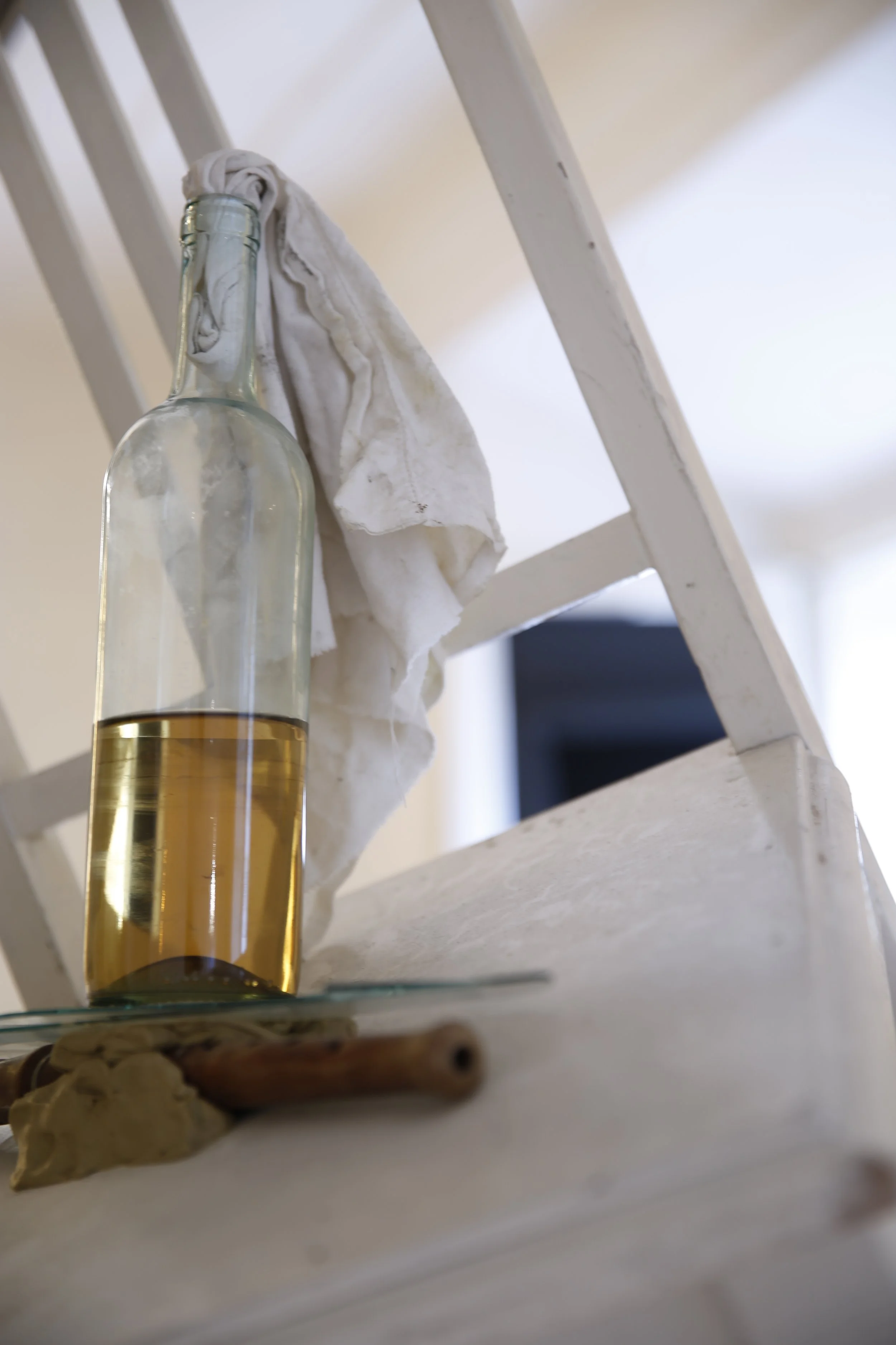 Hängender weißer Stuhl mit Glasflasche und Tuch vor einer Wand aus Bienenwaben, Kunstinstallation, Kulturzentrum bei den Minoriten, Graz, Ausstellung des aktuellen Künstlers Eduard Winklhofer aus Düsseldorf