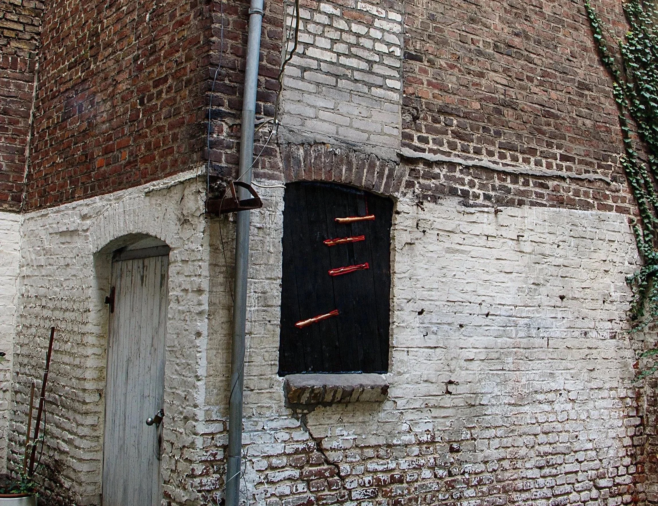 Installation im Raum für Kunst Düsseldorf, von zeitgenössischem Künstler Eduard Winklhofer, Flöten, verbranntes Holz, Roter Stoff