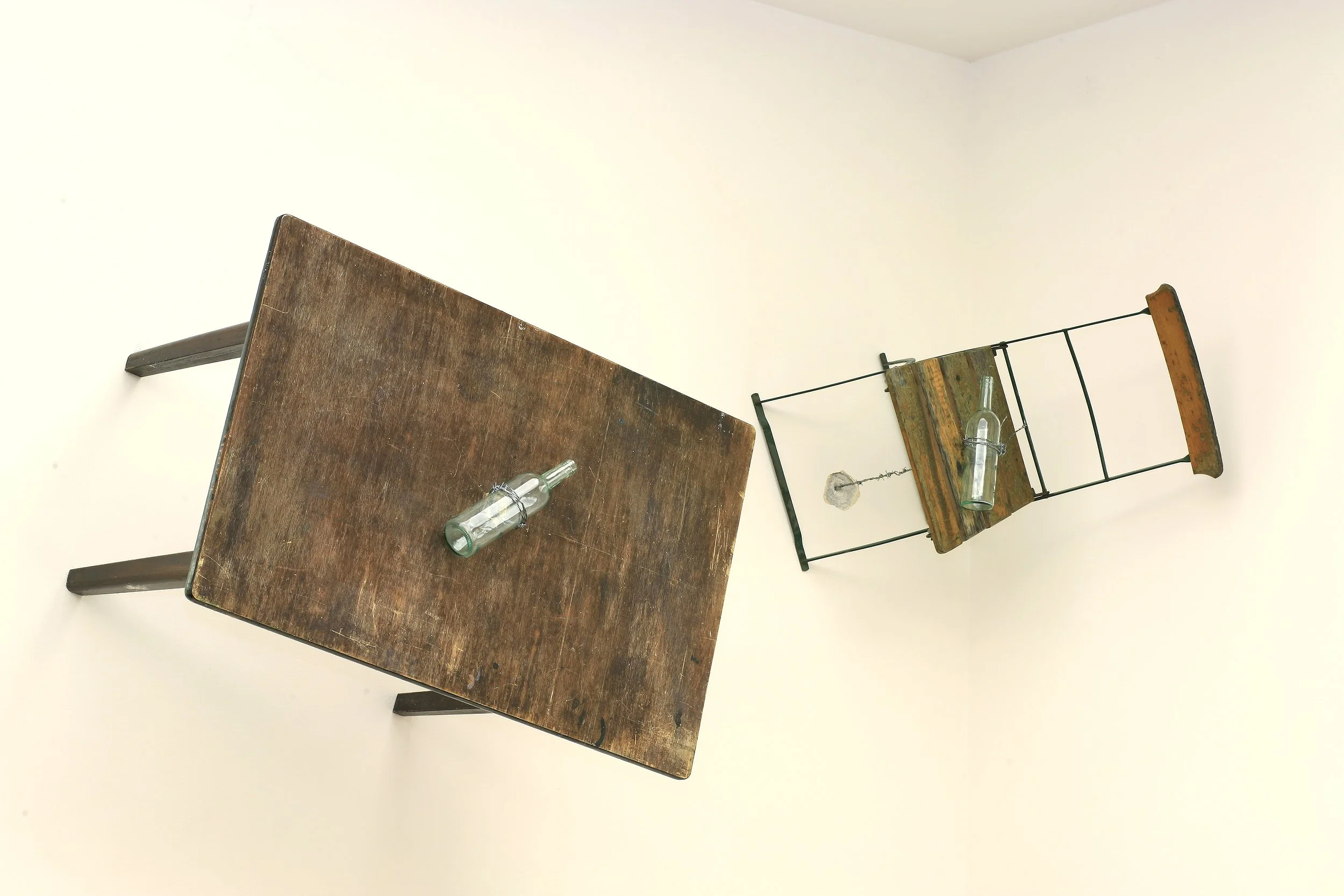 Große Installation, Stühle die durch Stacheldraht der an Flöten/Flaschen befestigt ist und durch die Wand verläuft, vertikal an dieser gehalten werden, Ausstellung vom zeitgenössischen Düsseldorfer Künstler Eduard Winklhofer, in La Spezia 90er Jahre