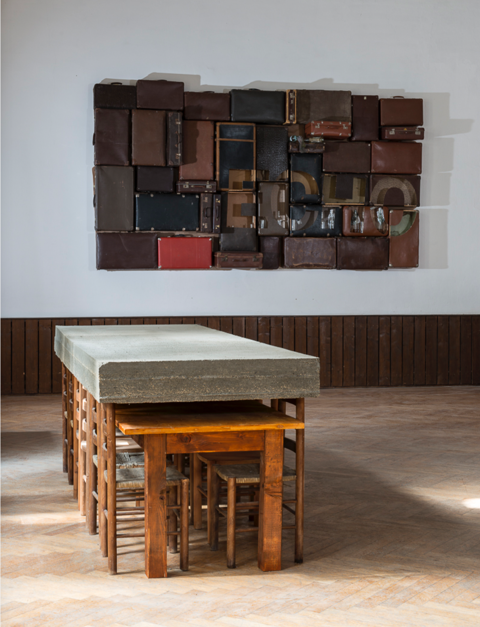 Installationen aus Betonblock auf Holzstühlen und Wand aus Koffern, Echo, Arbeit des österreichischen zeitgenössischen Künstlers Eduard Winklhofer 