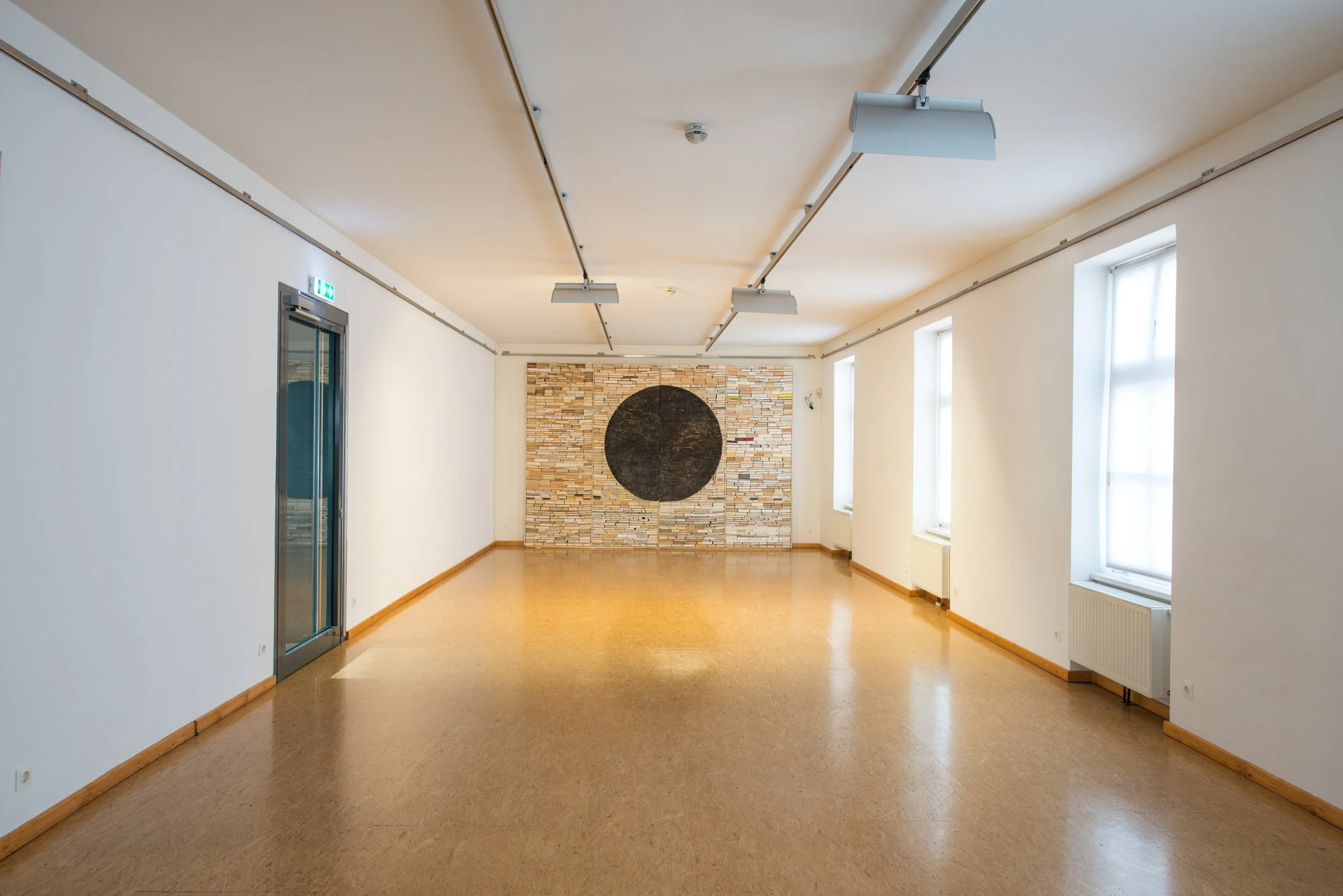 Wand aus Büchern, ausgehöhlter schwarzer Halbkreis, Kunstinstallation, Kulturzentrum bei den Minoriten, Graz, Ausstellung des aktuellen Künstlers Eduard Winklhofer aus Düsseldorf