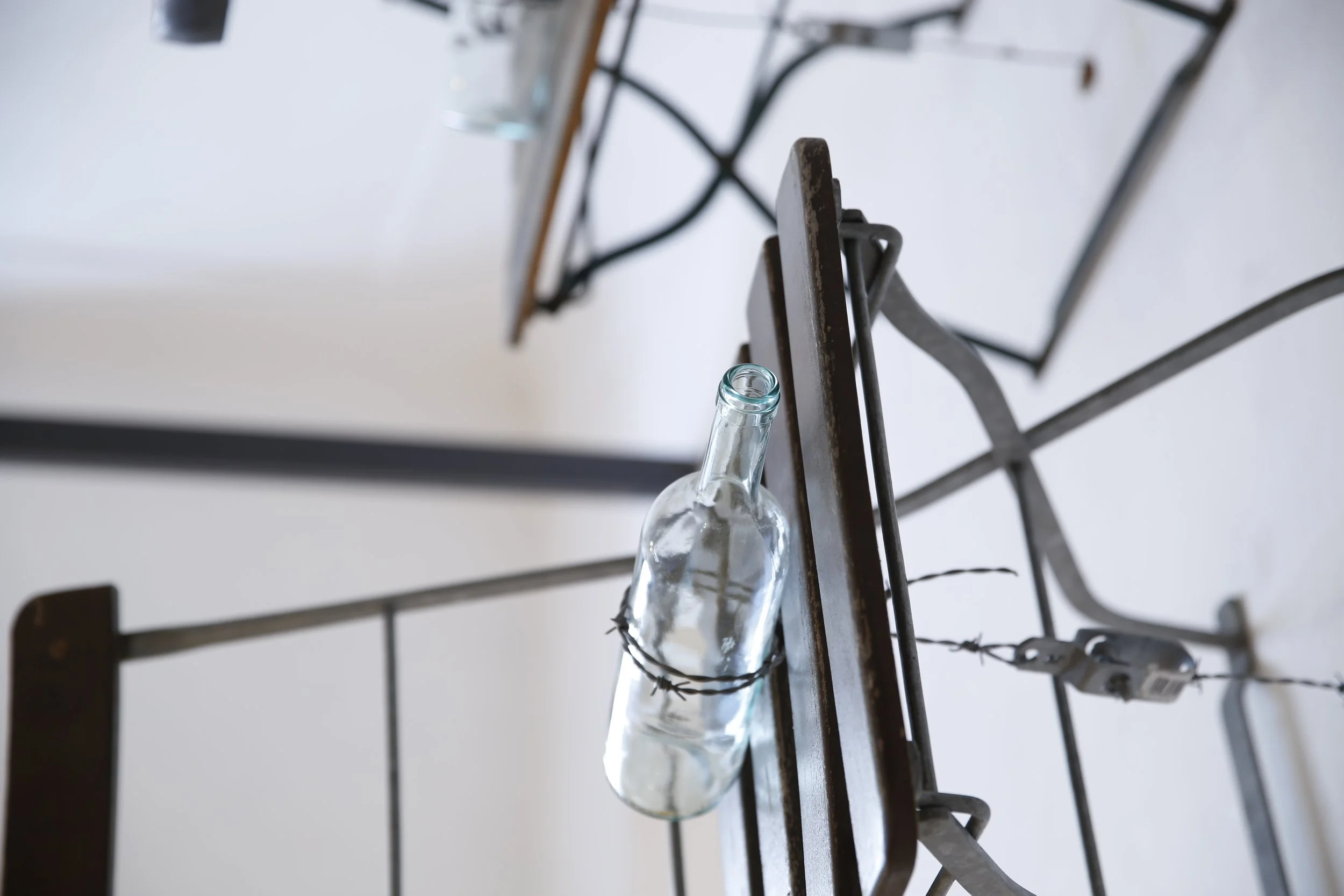 Kunstinstallation, Holzflöten und Stacheldraht halten Tische und Stühle auf der anderen Seite der Wand,  Kulturzentrum bei den Minoriten, Graz, Ausstellung des aktuellen Künstlers Eduard Winklhofer aus Düsseldorf 