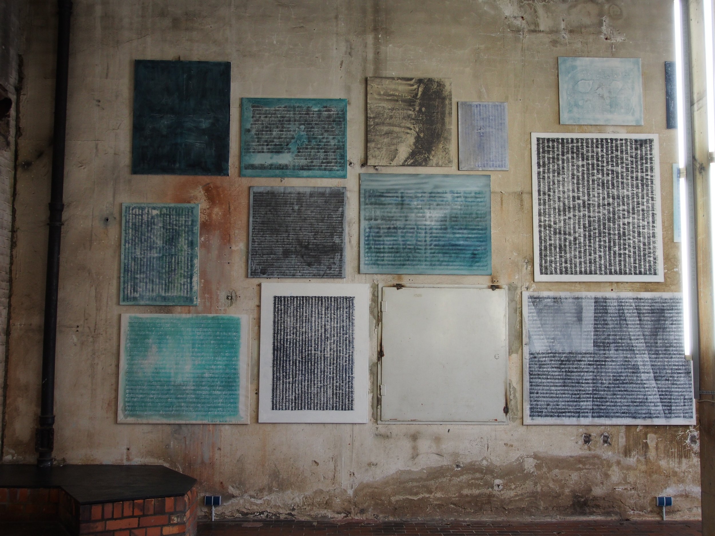 Mehrere Kunstwerke mit Textmustern Bilderwand und Installation im Kesselhaus Bamberg Ausstellung des aktuellen Künstlers Eduard Winklhofer aus Düsseldorf