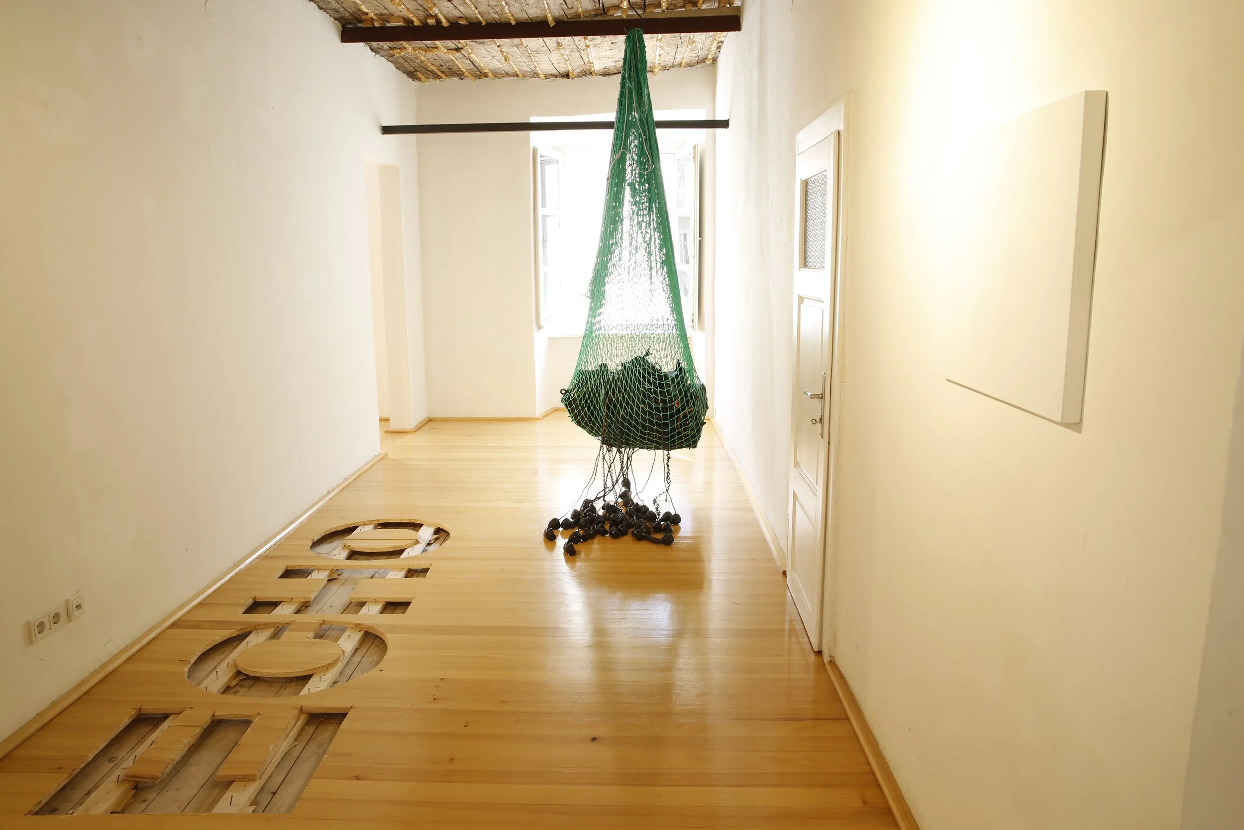 Kunstinstallation, Echo in den Boden gesägt, Netz das schwarze Telefone hält,  Kulturzentrum bei den Minoriten, Graz, Ausstellung des aktuellen Künstlers Eduard Winklhofer aus Düsseldorf 