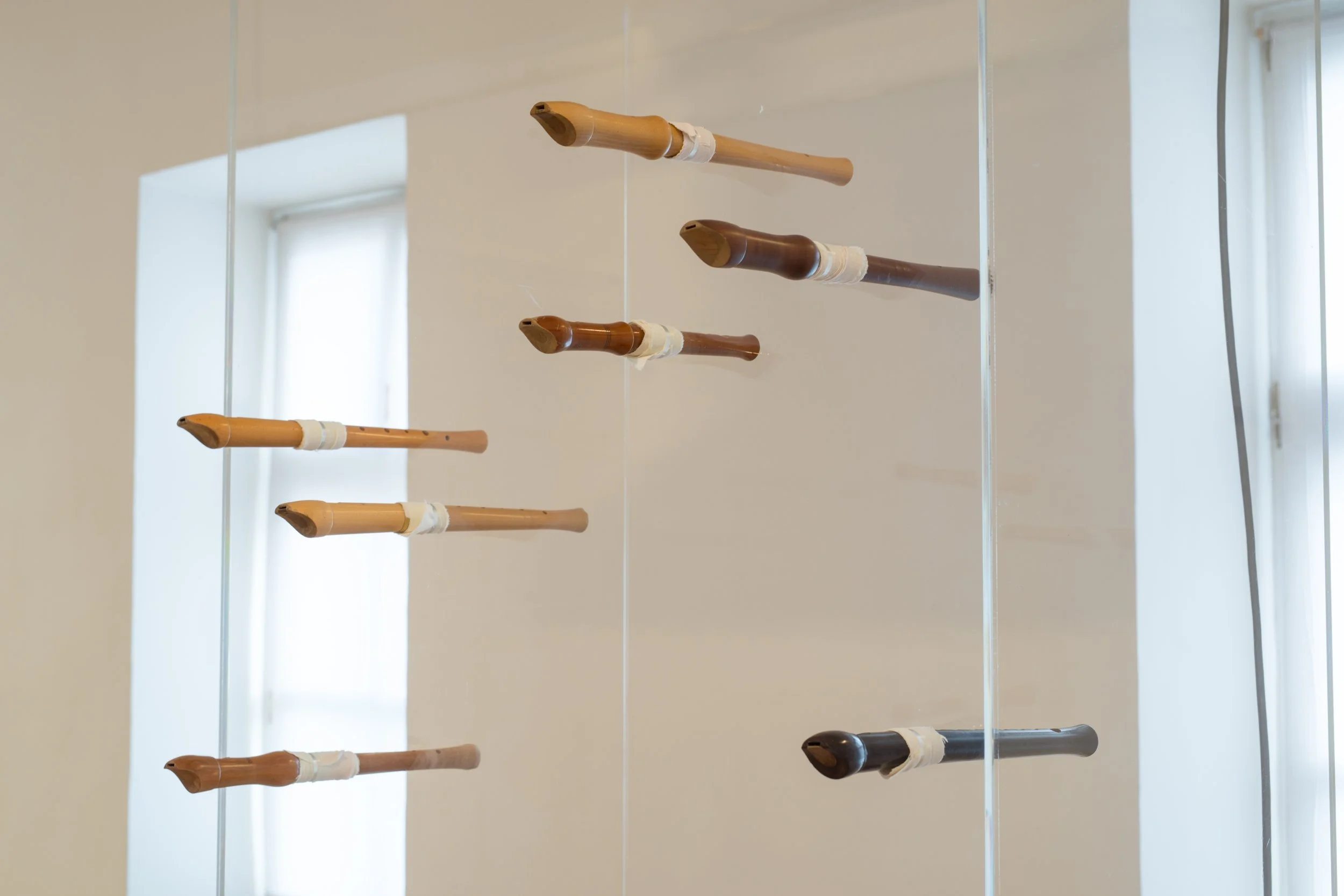 Fünf verschiedene historische Flöten aus Holz, in Glasscheibe, Kunstinstallation, Kulturzentrum bei den Minoriten, Graz, Ausstellung des aktuellen Künstlers Eduard Winklhofer aus Düsseldorf