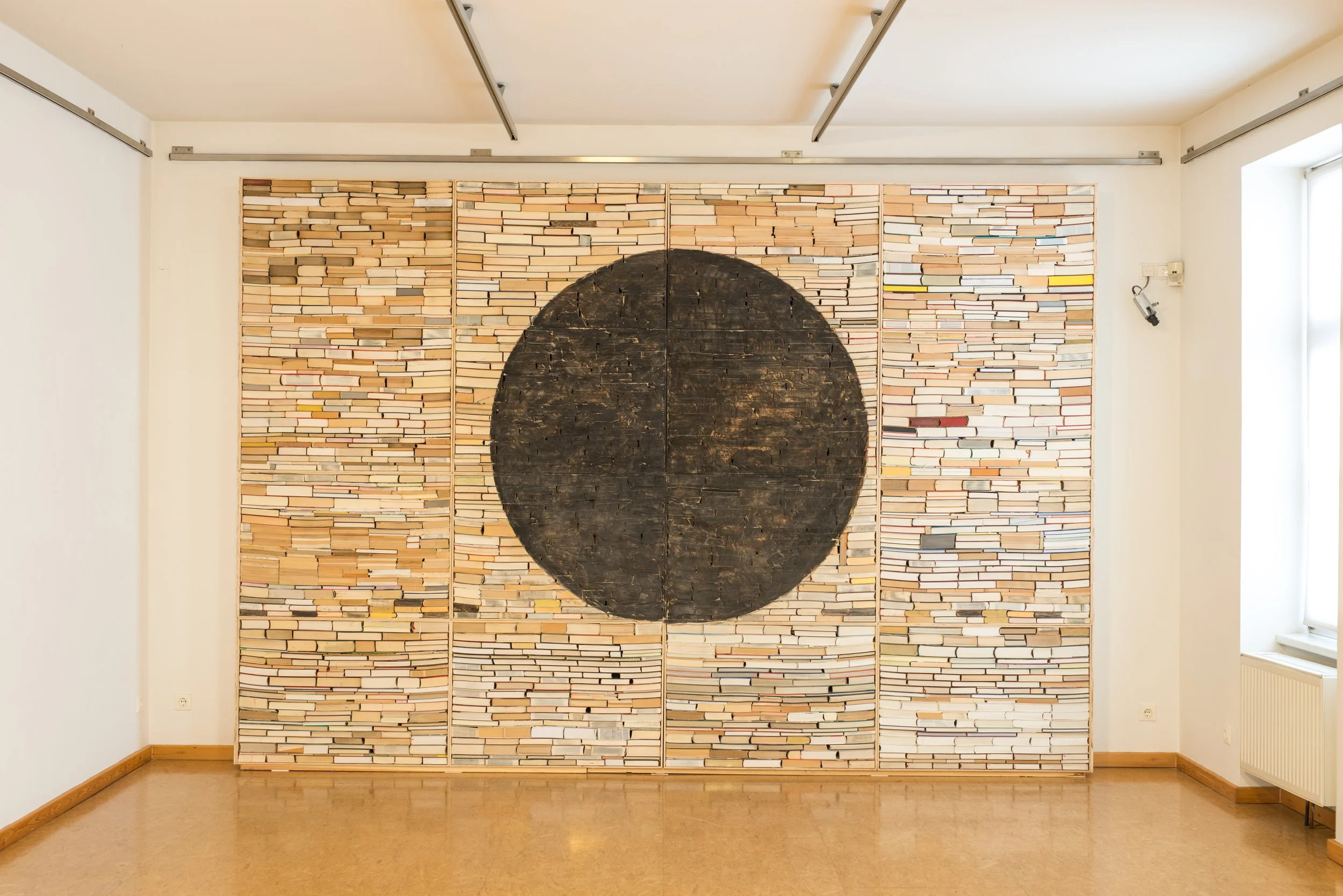 Wand aus Büchern, ausgehöhlter schwarzer Halbkreis, Kunstinstallation, Kulturzentrum bei den Minoriten, Graz, Ausstellung des aktuellen Künstlers Eduard Winklhofer aus Düsseldorf