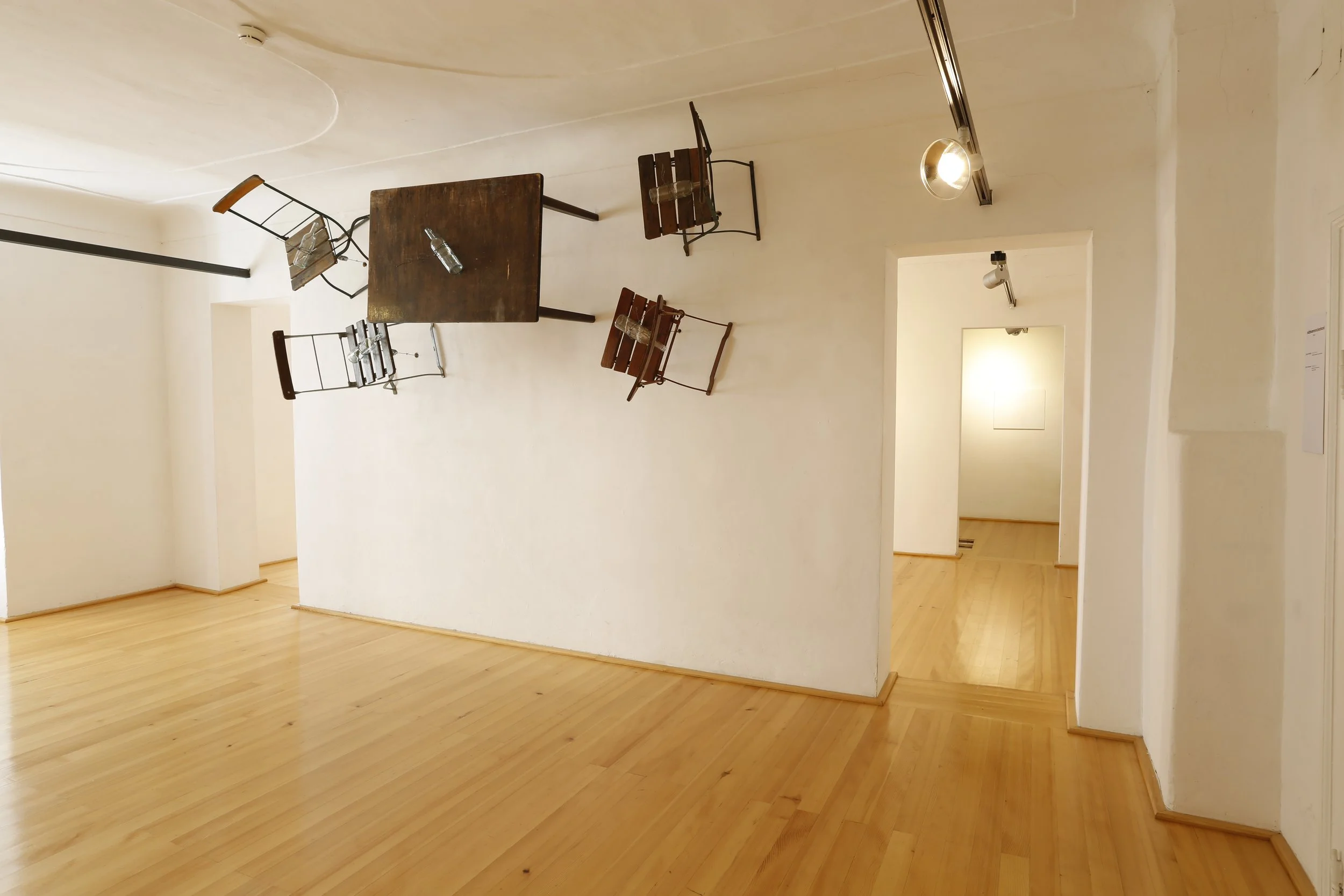 Kunstinstallation, Holzflöten und Stacheldraht halten Tische und Stühle auf der anderen Seite der Wand,  Kulturzentrum bei den Minoriten, Graz, Ausstellung des aktuellen Künstlers Eduard Winklhofer aus Düsseldorf 