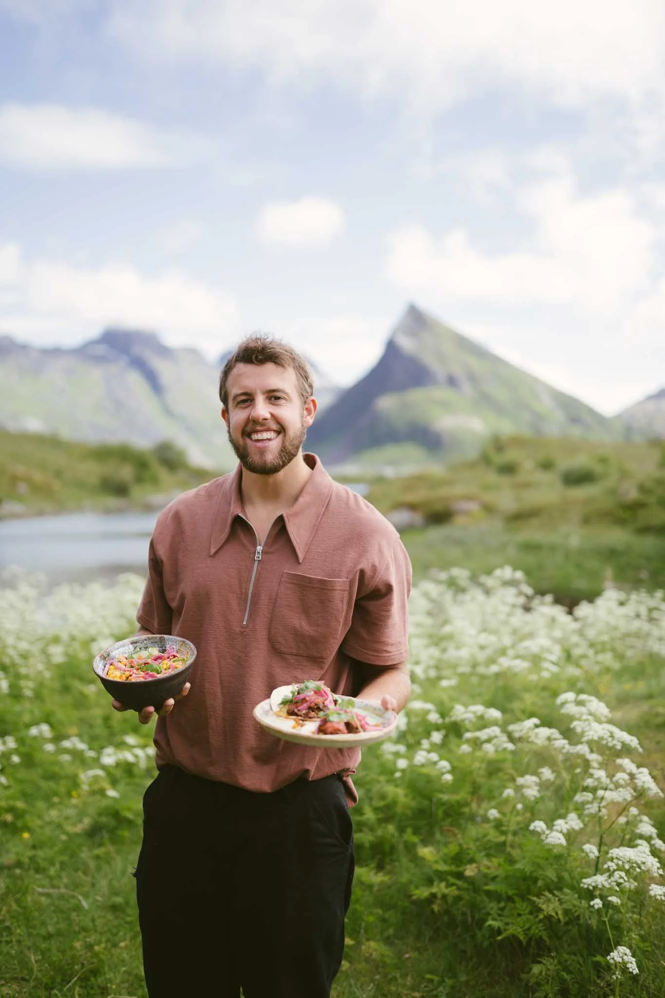 Ung mann presenterer rettene sine foran en nydelig utsikt. 
