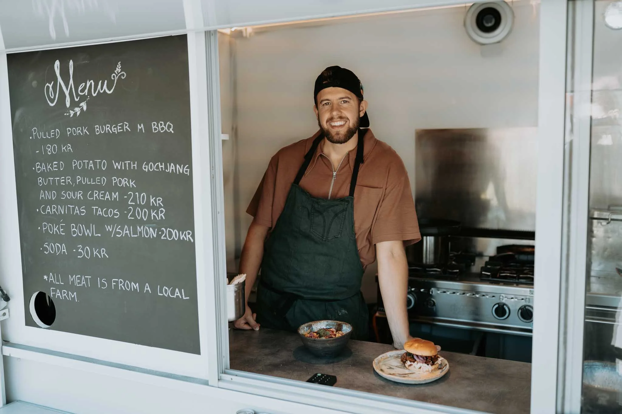 Smilende kokk i food truck. 