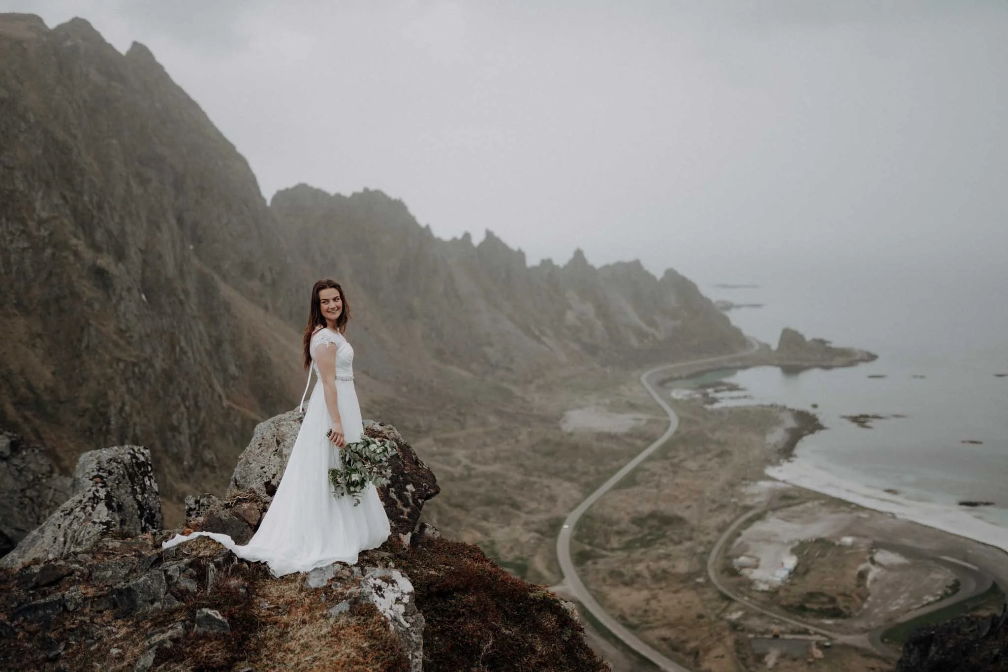 Portrettfotografering på et fjell i Bleik. Brud står ved en spektakulær utsikt.