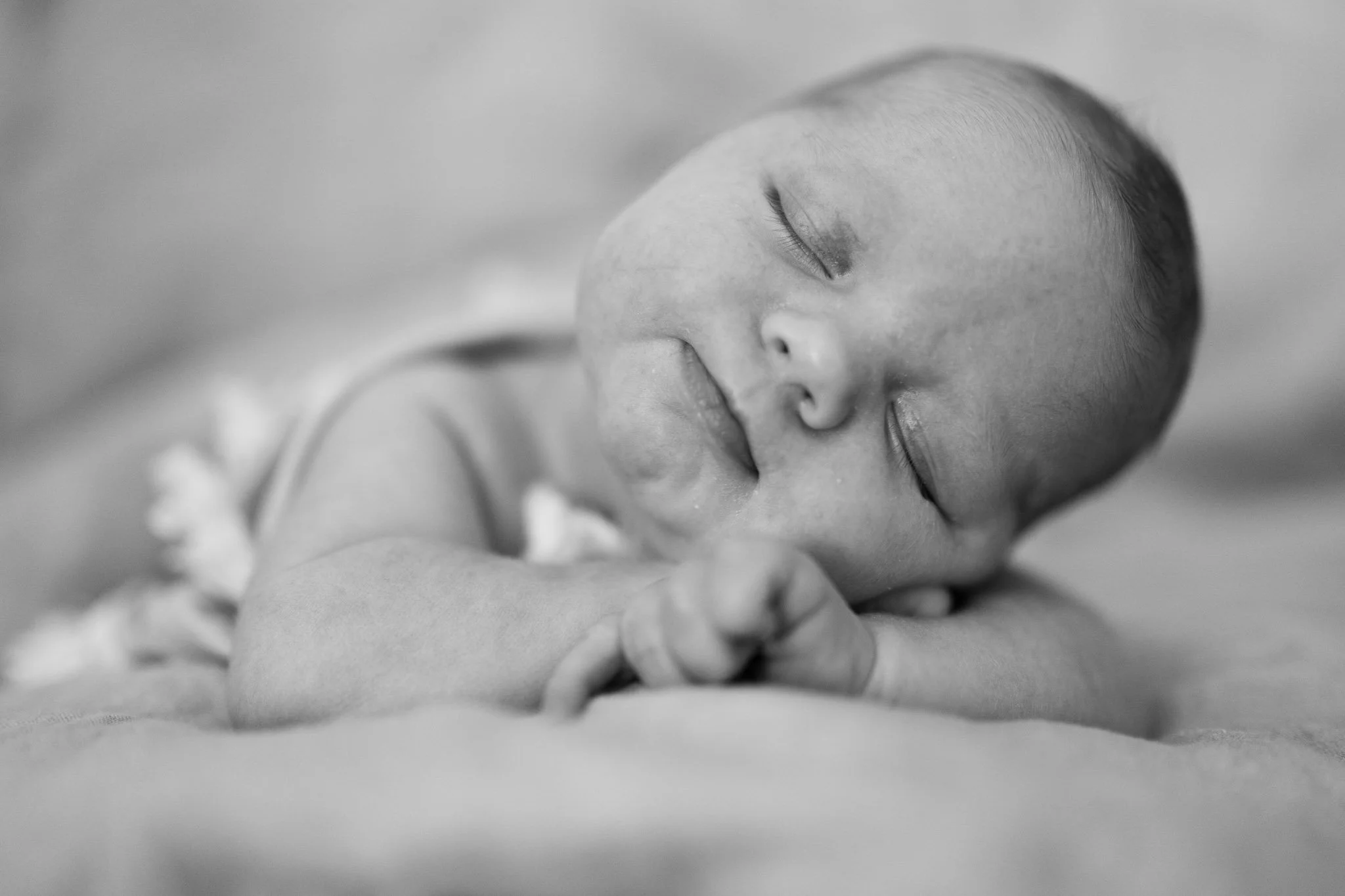 Søvnende baby nærbilde i svart-hvitt.
