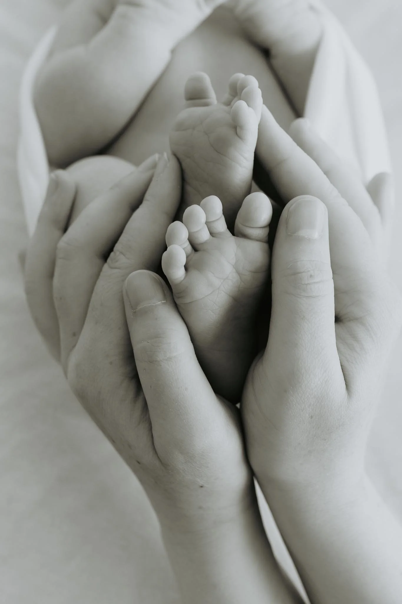 Mor holder rundt føttene til babyen.