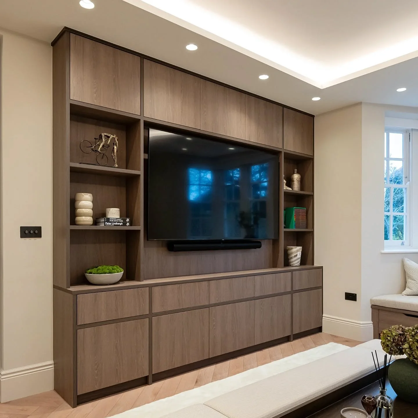 This TV wall combines a mix of materials to create an elegant and warm feel. Made entirely from Egger, it features a combination of Brown Orleans Oak and a slightly darker Marone Cassella Oak for the front edge detailing.
It is handleless, with push-