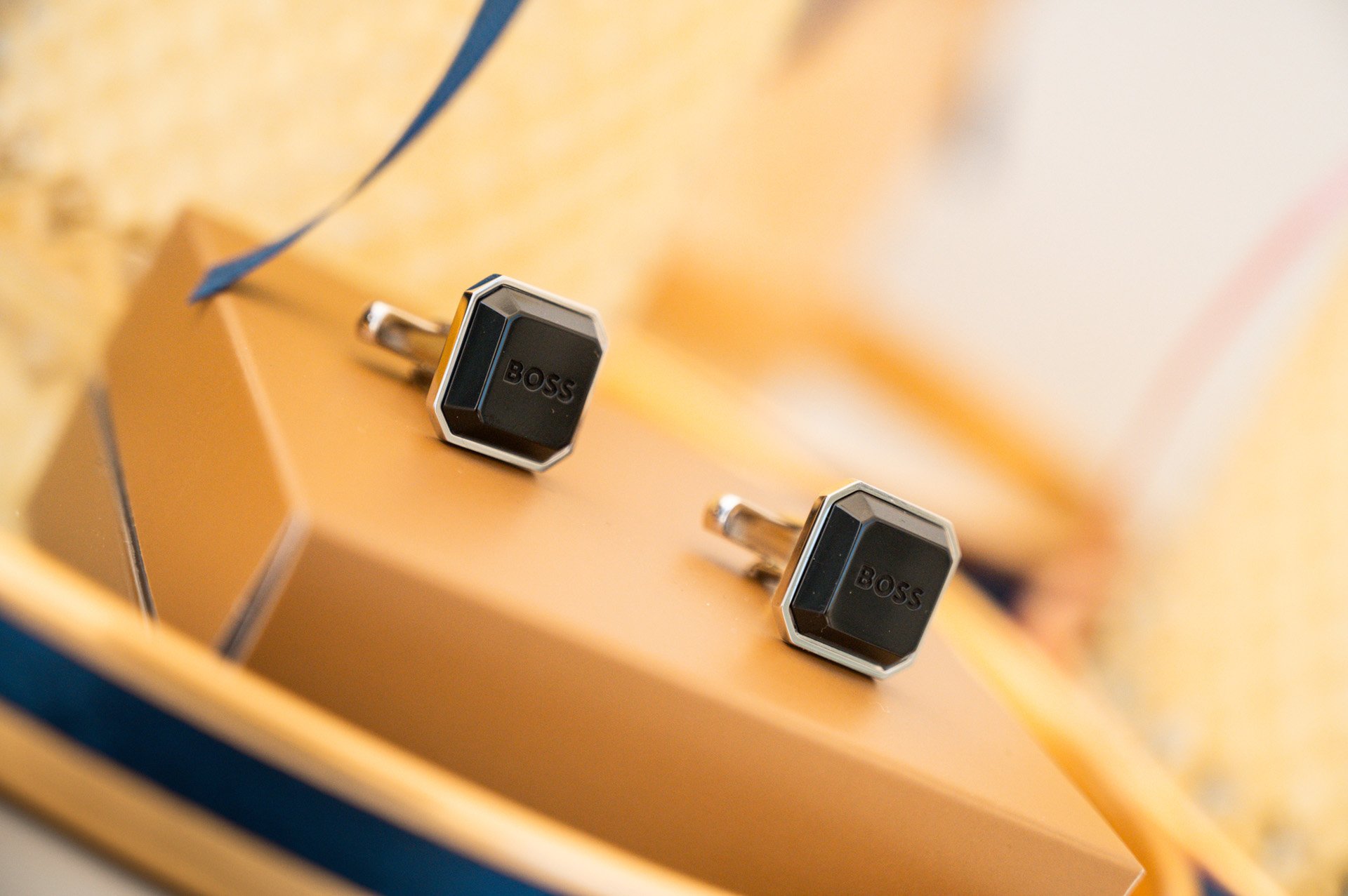 Close-up of a guitar's headstock with black BOSS tuners, mounted on a wooden guitar neck.