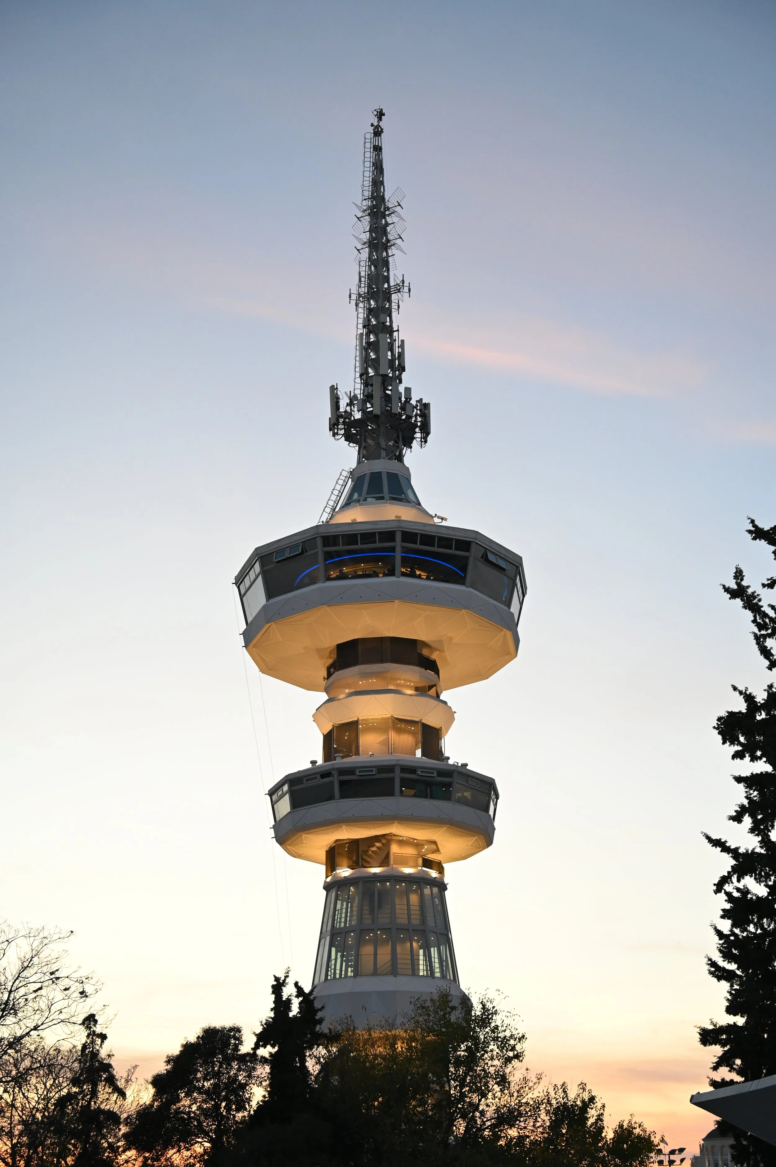 Arial view of the Space Needle during sunset with clear sky and trees in the foreground.