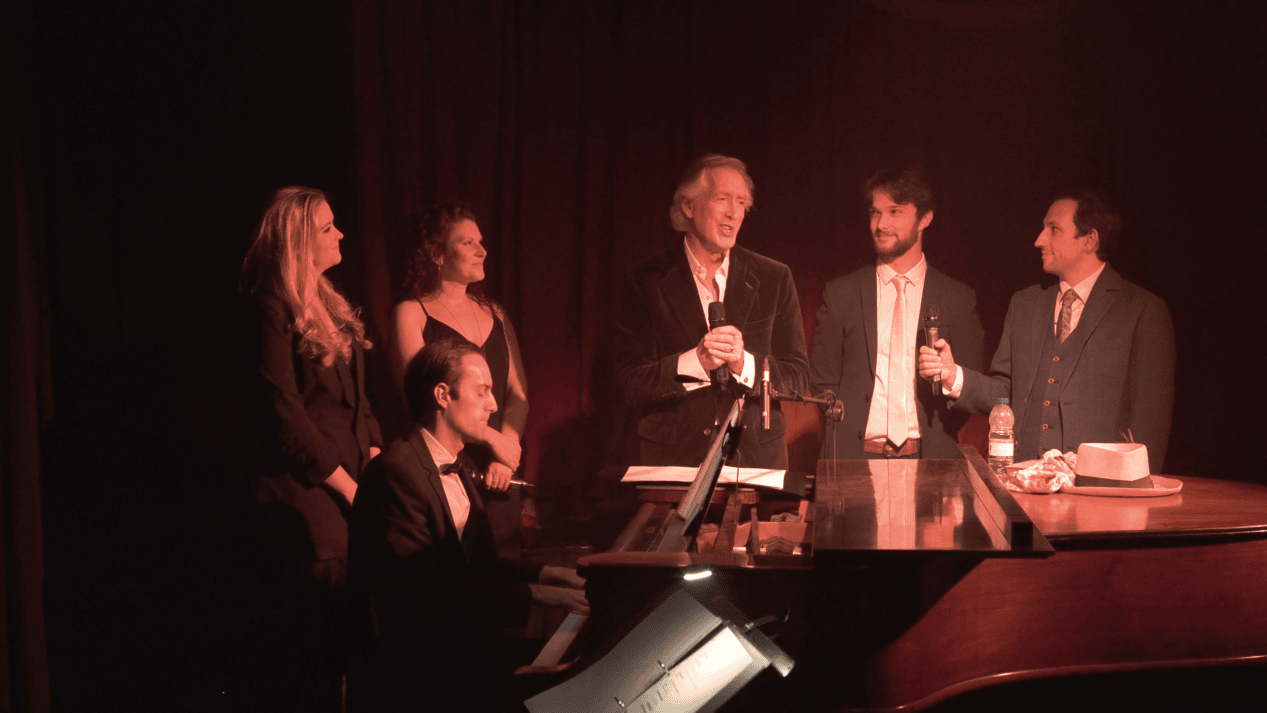 Peter Land with Alice Rose Fletcher, Christina Meehan, Oliver Mawdsley, Nick Southcott and Laurie Denman at the piano
