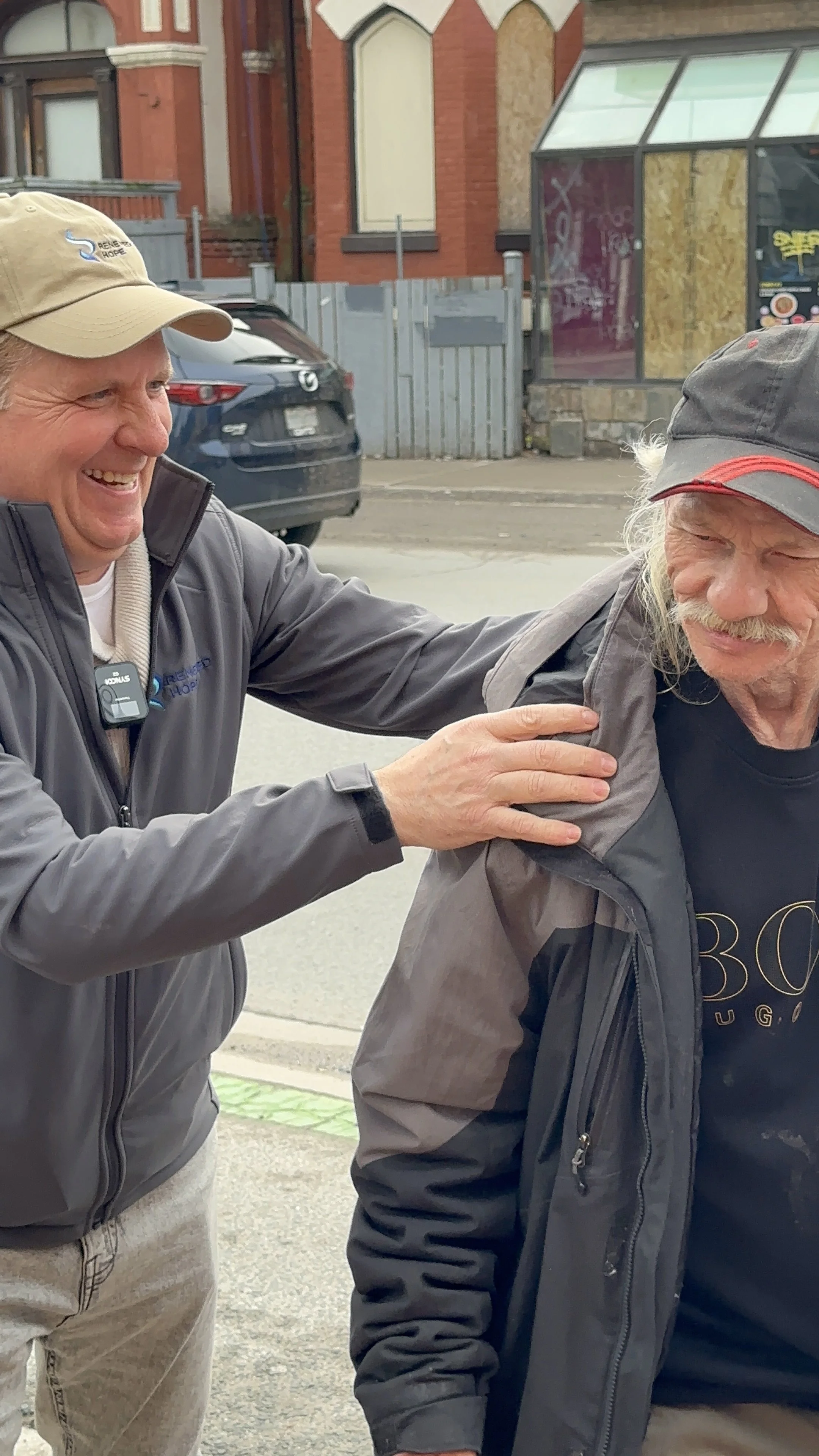 renewed-hope-volunteer-laughing-on-street-with-man-facing-adversity