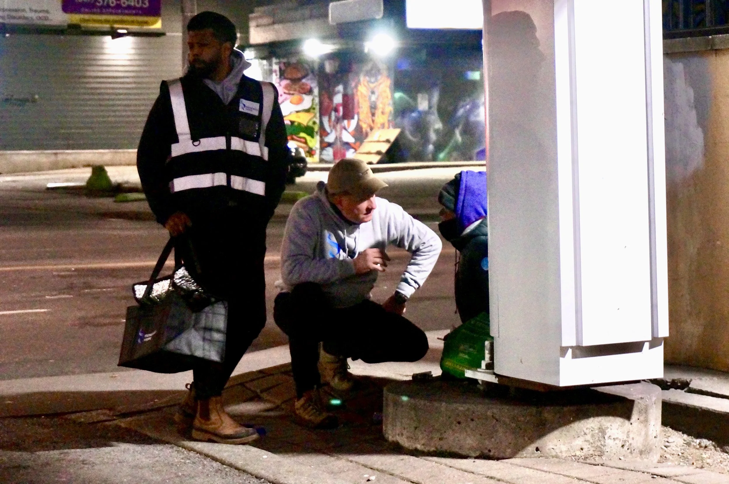 renewed-hope-volunteer-sitting-with-helping-homelesss-man-on-street