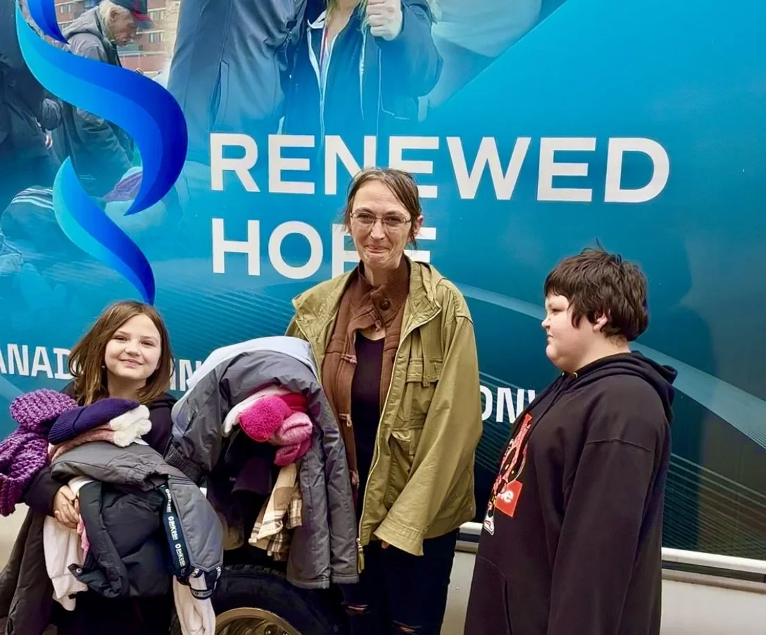 Renewed-Hope-Volunteer-kneeling-on-street-helping-homeless