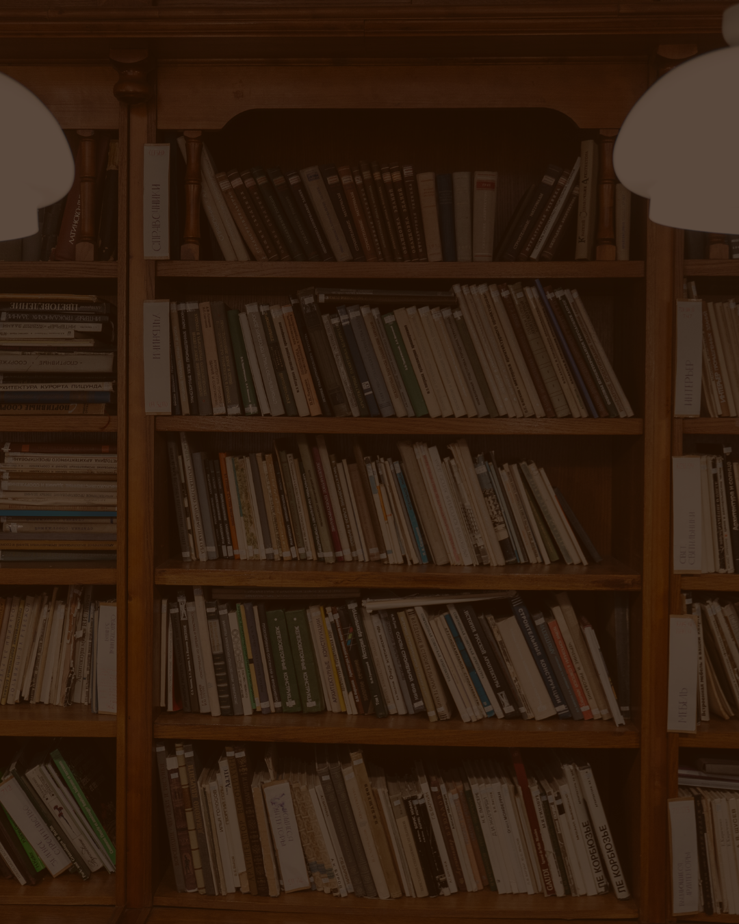 Wooden bookshelves filled with numerous books in a library setting.