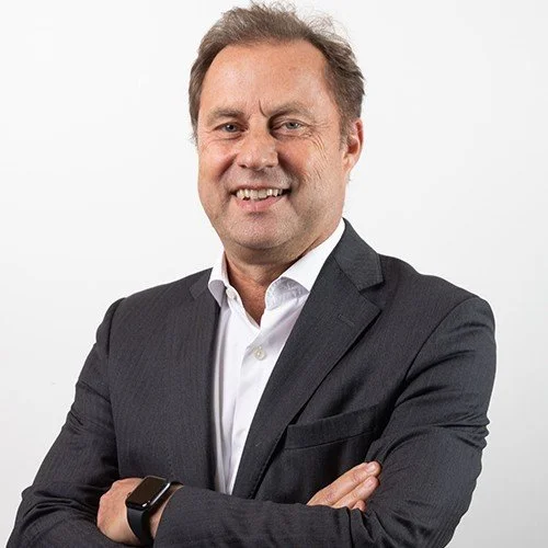 Smiling businessman with crossed arms in a suit