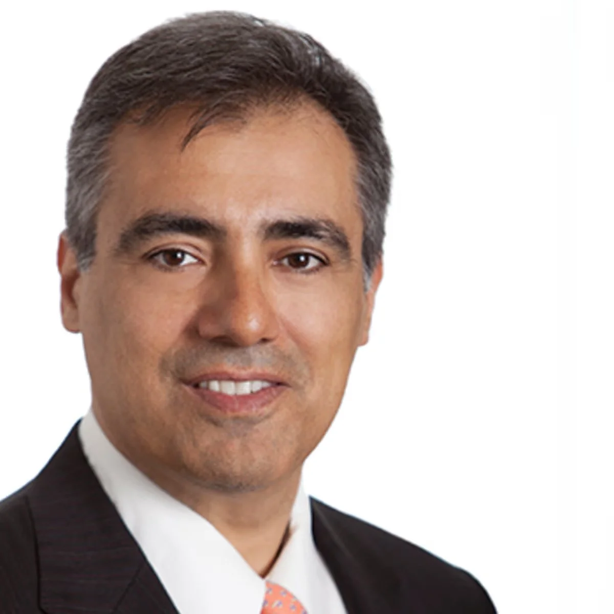 Man in a suit with a white shirt and orange tie, smiling, isolated on a white background.
